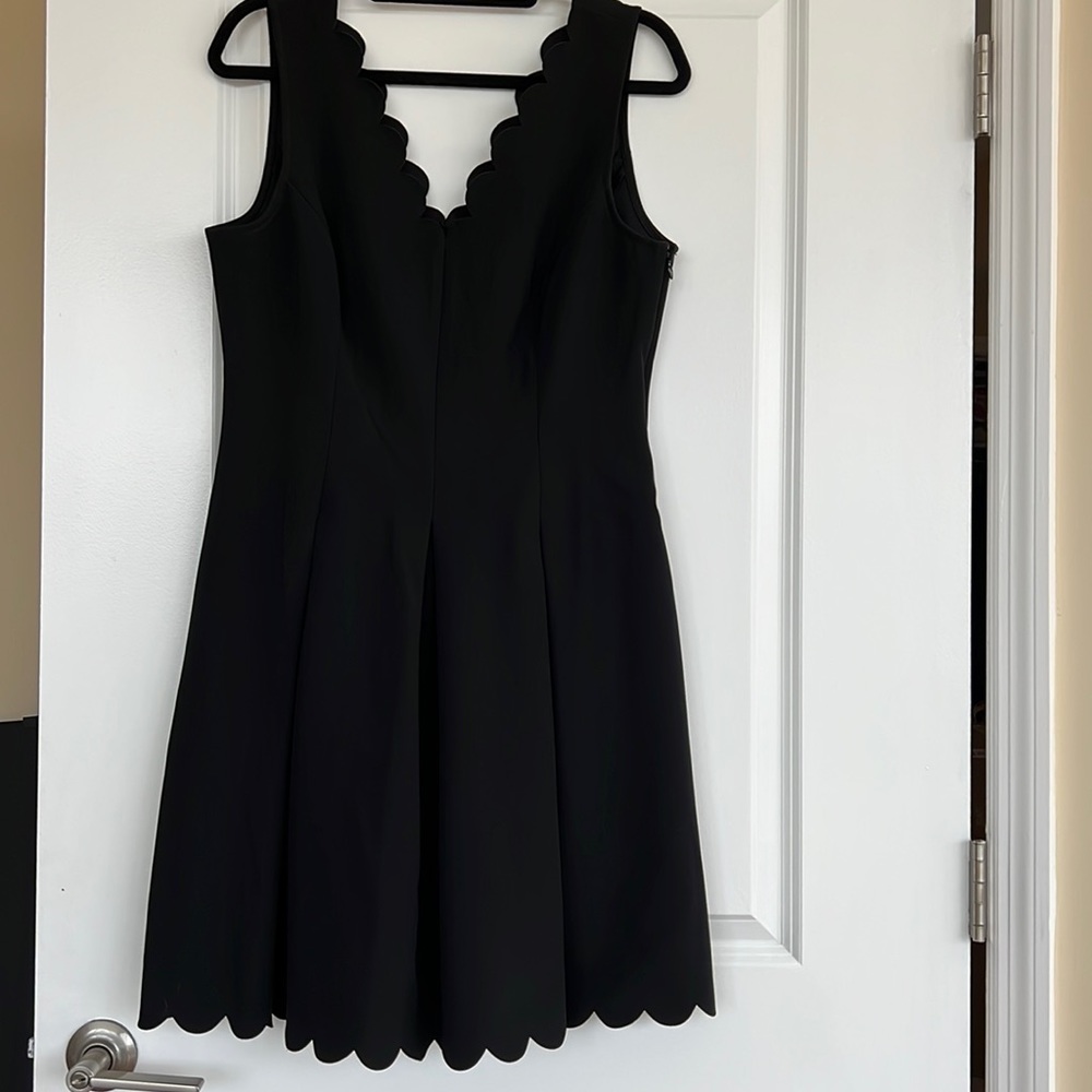 Black dress with scalloped edging.
